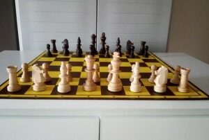 houten set schaakstukken en plooibord met zakje of doosje